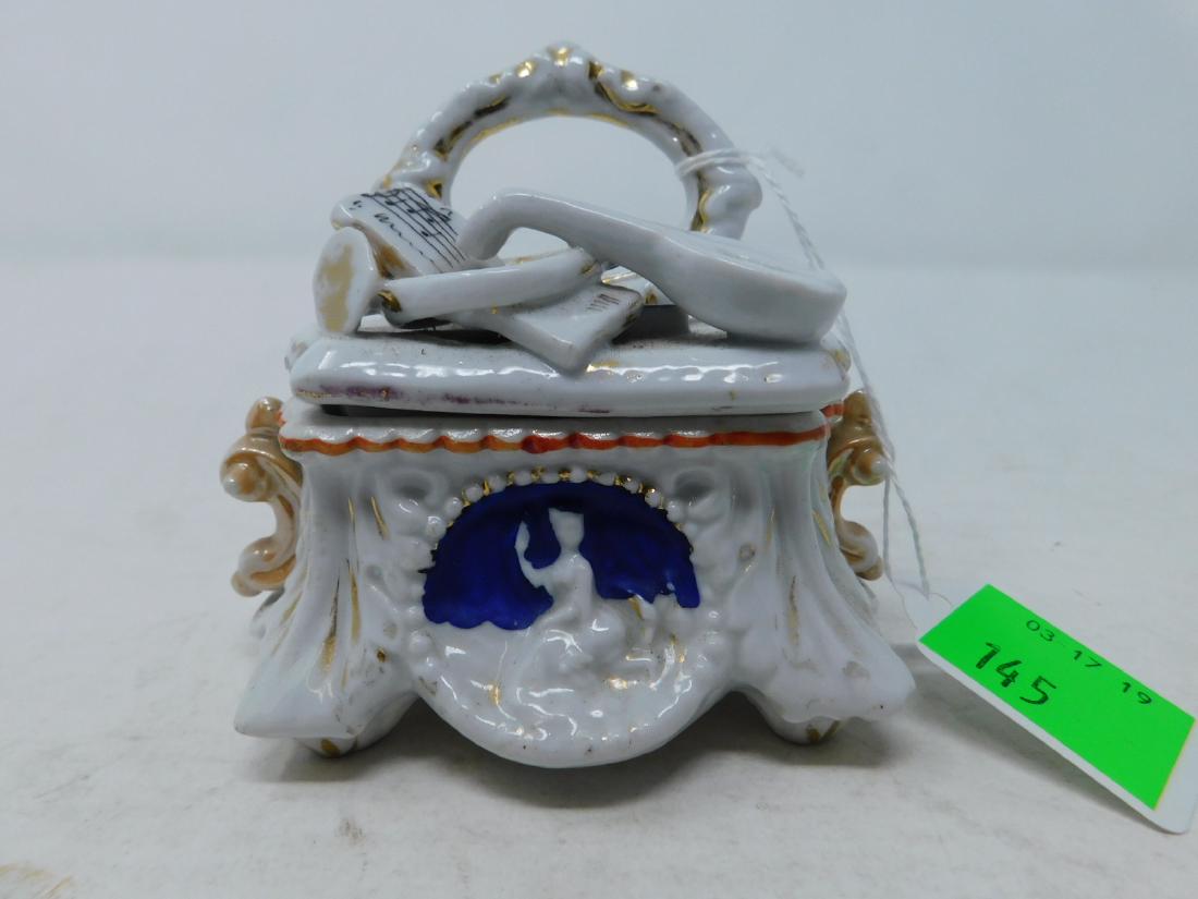Vieux Paris Porcelain Figural Box: Vieux Paris Porcelain Figural Box: Old Paris porcelain figural box in the form of a group of musical instruments in front of a mirror on an elaborate table. 19th c. Provenance: Robert A Goldstein. Siz