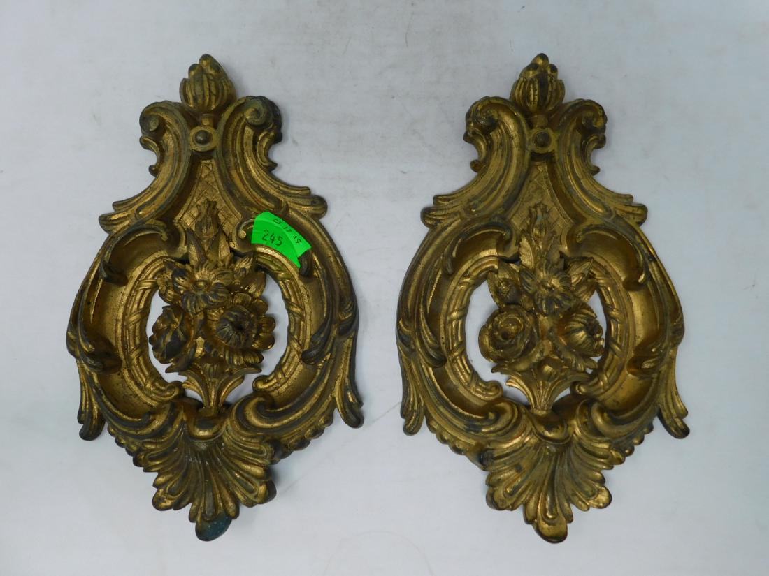 Pair Gilt Brass Curtain Tiebacks: Pair Gilt Brass Curtain Tiebacks: in the Rococo Revival style, complex frames surrounding central floral bouquets. Mid-late 19th century. Probably French. Size: 10" tall. CONDITION: Lacking mounting p