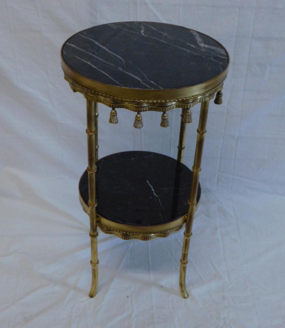 Designer 2 Tier Stand: Designer 2 Tier Stand, distressed gilt finished metal stand with tassel drops, rope borders, four bamboo form legs and inset veined black marble top and base shelf, 21st C., 15 3/4" x 28". CONDITION: