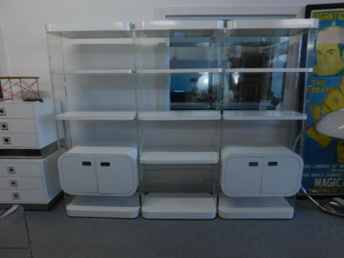 Modern Era Lucite / Formica Wall Unit: Modern Era Lucite / Formica Wall Unit, clear lucite uprights support a central etergiere with white formica open shelves and flanked on each end by two double door ovoid suspended cabinets with shelve