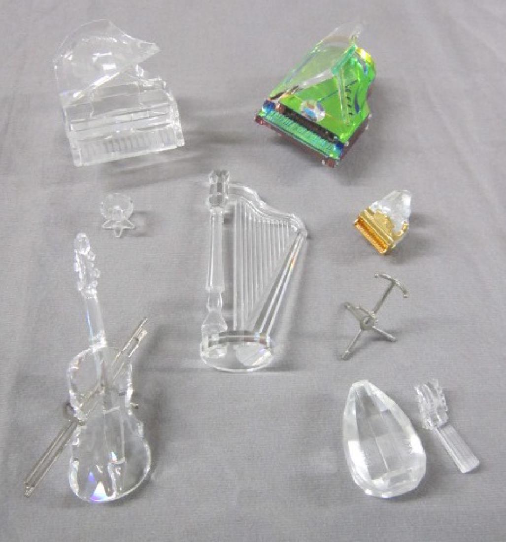 Swarovski Crystal Grouping: Swarovski Crystal Grouping, musical instruments including: harp, 4 1/4"h; three baby grand pianos, one with amber color interior, 3"l x 2 1/2"h; one clear crystal, 2 1/2" x 2 3/4" h with small round s