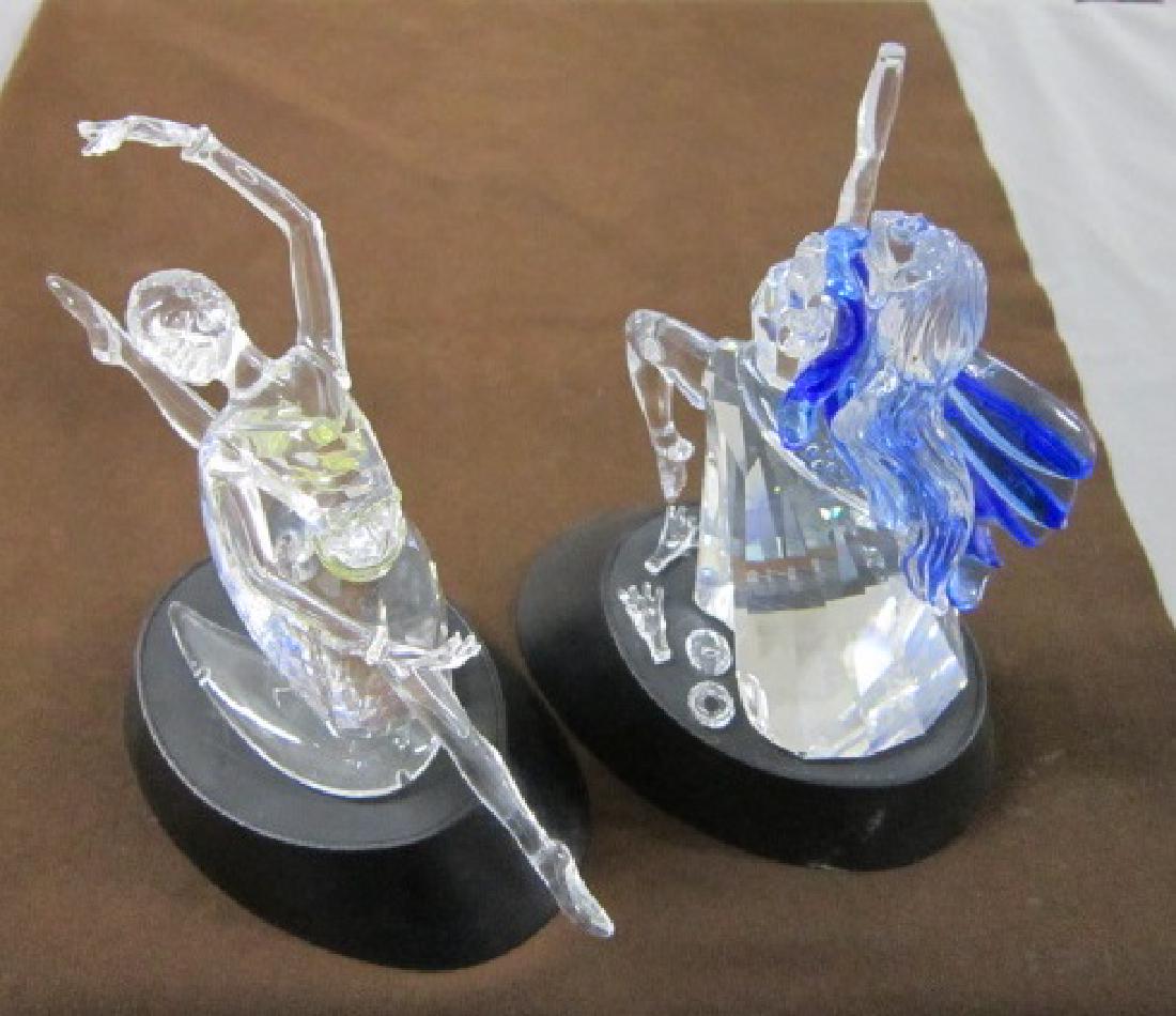 2 Swarovski Crystal Magic of Dance Figures: Two Swarovski Crystal Magic of Dance Figurine, "Isadora", 7" and 2004 (3rd Annual) Magic of Dance Figurine, "Anna", 7 1/2", both on Swarovski black plastic stand. CONDITION: "Isadora" figure has detac