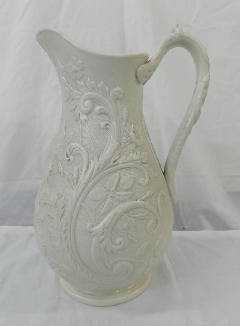 Antique Staffordshire Gothic Revival Jug: Antique Staffordshire Gothic Revival Jug: a smear-glazed white stoneware or Parian ware pitcher with molded Gothic revival and floral designs. Bifricutated handle. British registry and Staffordshire k