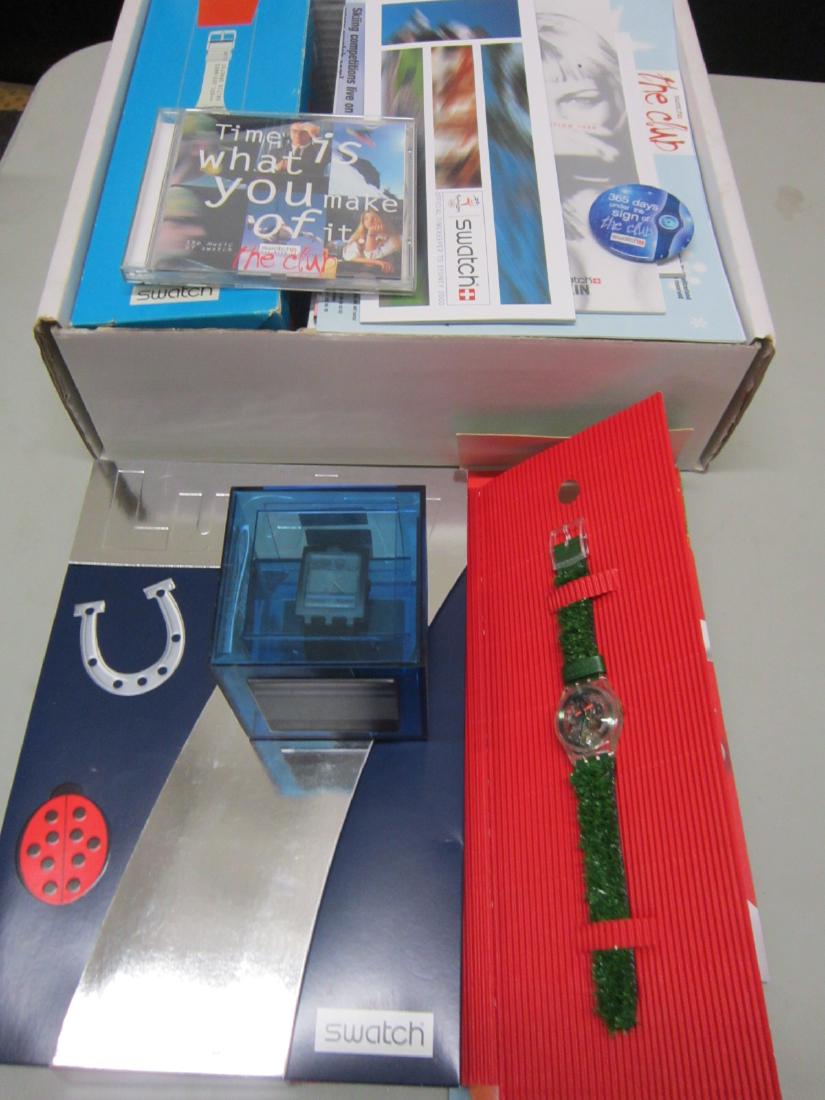 Swatch Club Watches & Other Club Items: Swatch Club Watches & Other Club Items including: four Swatch Watches, all new old stock in original packages including: one "Don't Be Too Square", Blue Town, SUAG 102, blue plastic cube container