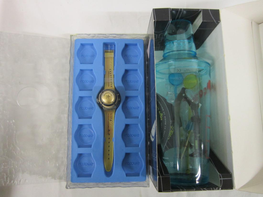 Two Swatch Watches In Original Packages: Two Swatch Watches In Original Packages, new old stock with folded information sheets including: Hang Over, GB 196 (set / pack), in fitted cardboard box with cocktail decoration, plastic cocktail shak