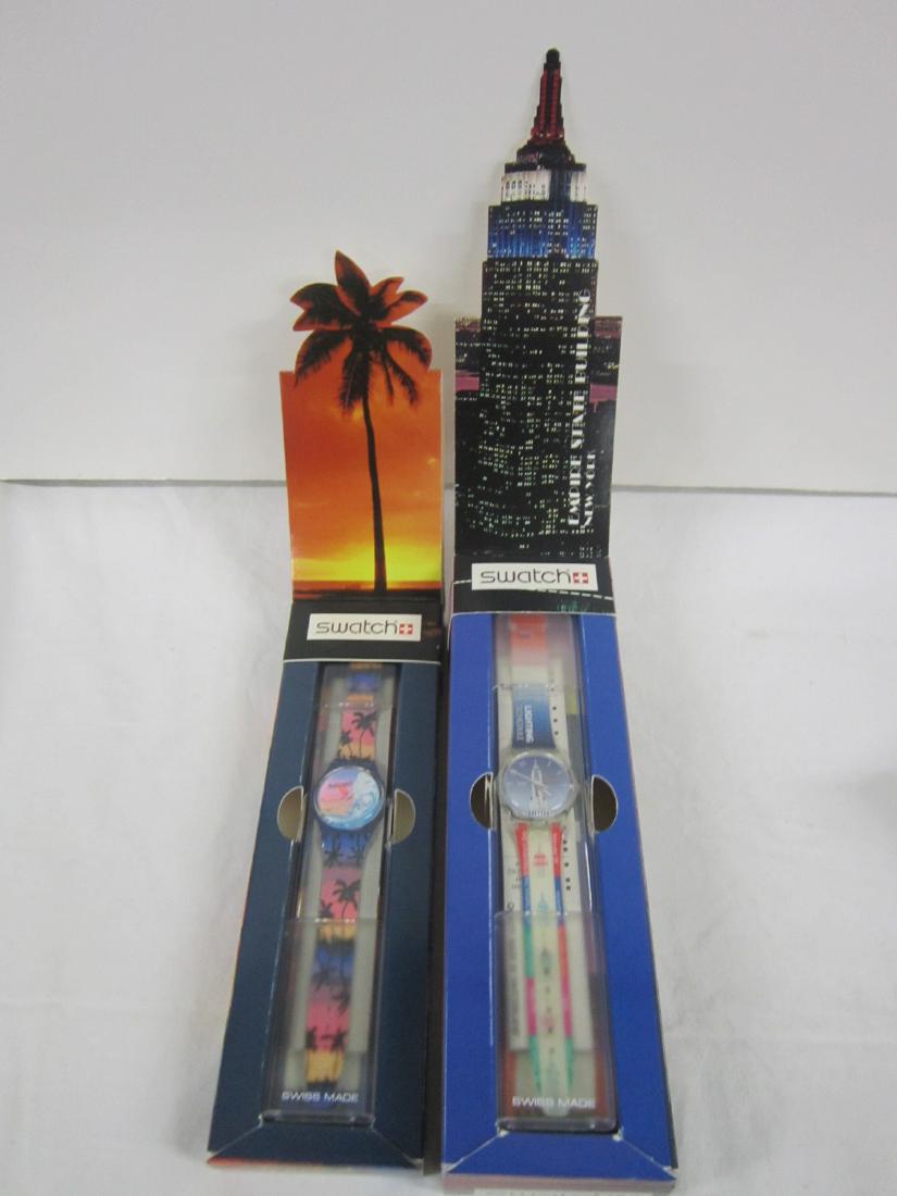 2 Swatch Watches In Original Boxes: 2 Swatch Watch in original boxes, both new old stock In hard plastic cases with fold up Diarama lids, folded formation and sheets including: Empire State Building, GK 309 (glow in the dark) and Tropic