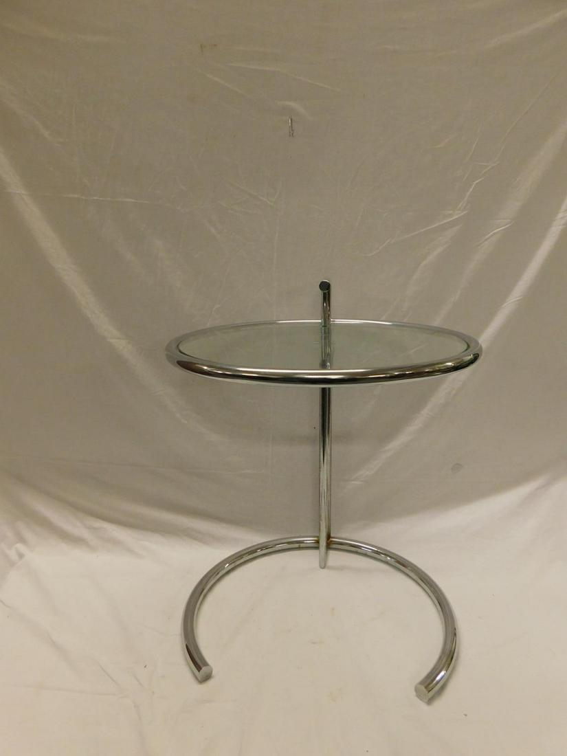 Eileen Gray Side Table: A vintage example of the adjustable, chromed metal and glass side table designed by Eileen Gray in the 1920s and designated E1027. Mid-20th c, tubular frame, glass top, 20" dia. x 25" h. late 20th c'