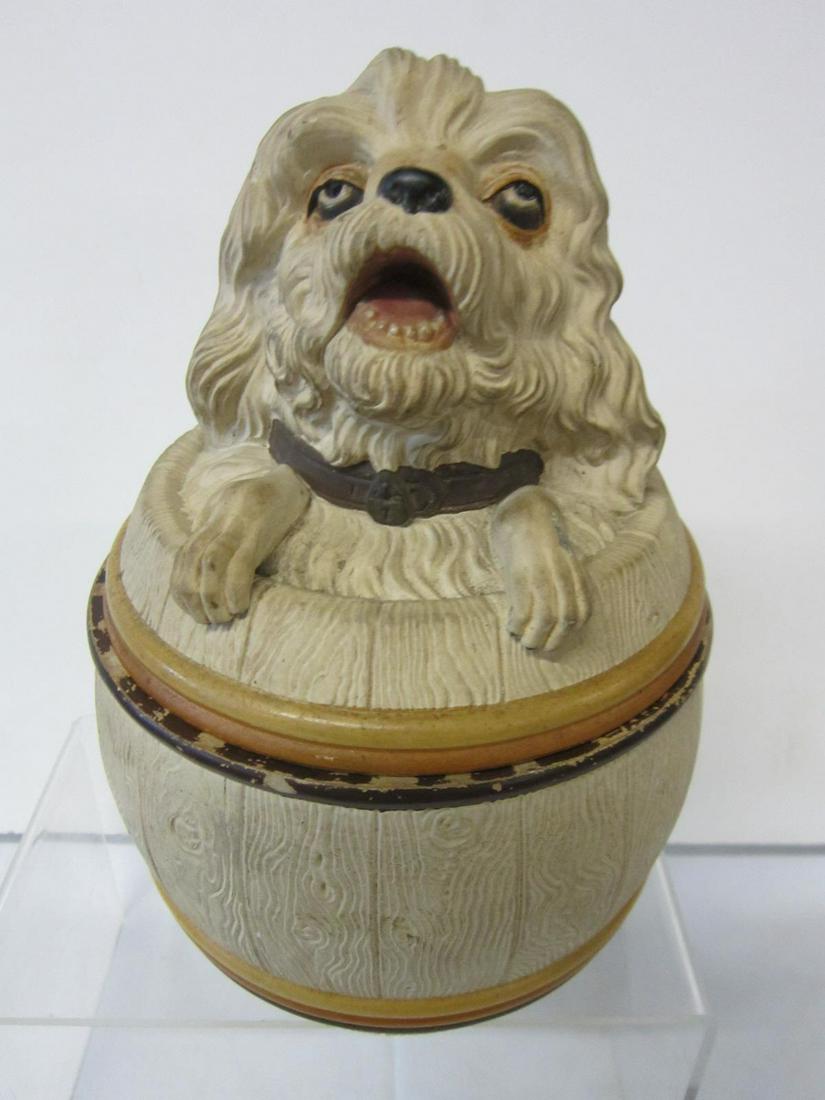 Pottery Tobacco Jar: Pottery Tobacco Jar features: sculptured and polychromed terrier dog bust on lid, barrel form base with incised mark "JM"? and #3167, pencil dedication with date Dec 25 1906, 7 1/2"h 5 1/2"d. CONDITIO