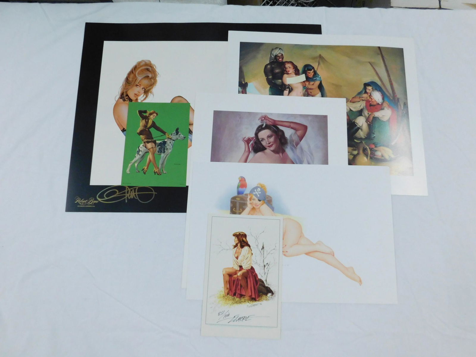 Pin-Up Prints Lot: [7 items] A lot of pinup prints, including: a Gil Elvgren of a woman with a Great Dane; A signed and numbered Larry Elmore; a numbered Zoe Mozert (dated 2000); A signed AB Dickens of a nude woman dres