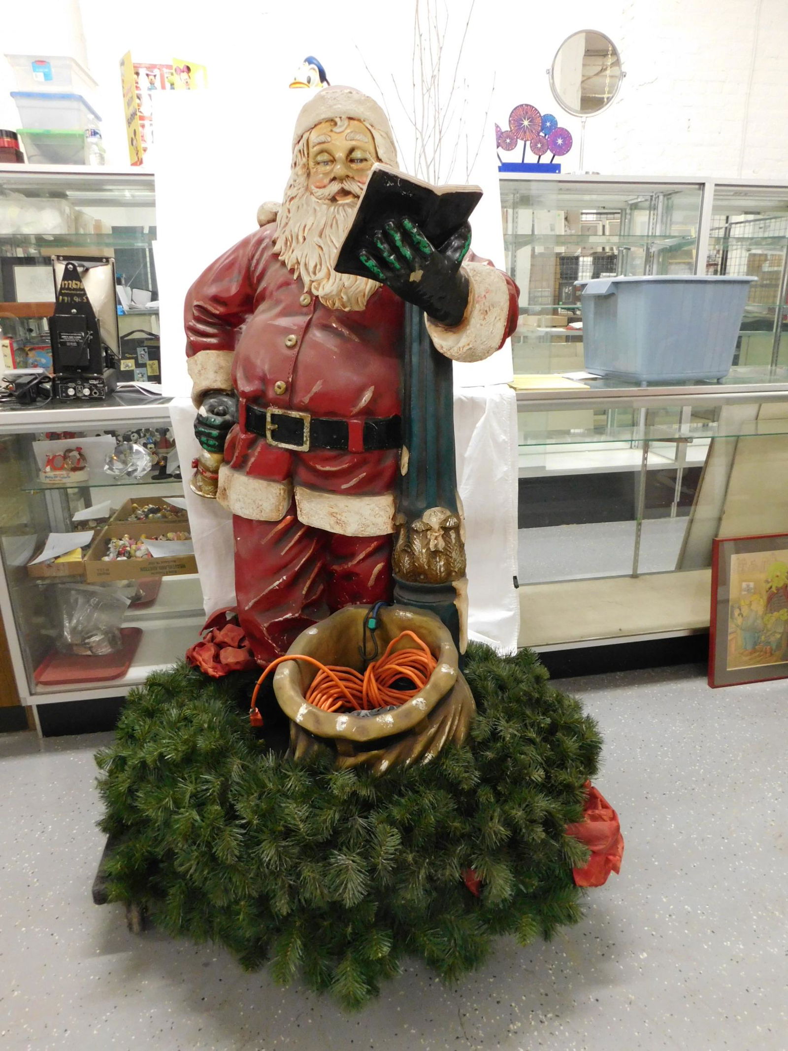 Resin Santa Department Store Display: Resin Santa Department Store Display, hand painted Santa reading while leaning on lamp post with sack at bottom, surrounded by two wreaths stacked and ribbons, 5"h with 42" d wreaths, with extension c