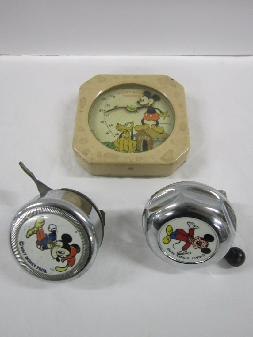 3 Vintage Disney Mickey Mouse Items: Three Vintage Disney Mickey Mouse Items including: two bike bells (one older, 1 newer), 2"d, plus: one tin hanging thermometer, 3 1/4" x 3 1/4" x 3/4". CONDITION: Some roughness and missing back mount