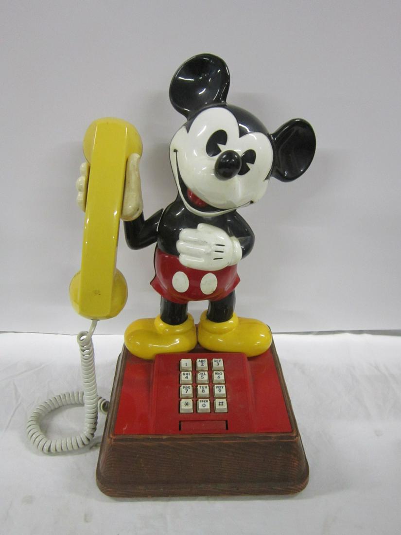 Mickey Mouse Telephone: Mickey Mouse Telephone, plastic Mickey Mouse figure on red plastic base top, faux wood base, push buttons with yellow hand set, 15 1/2" h, untested. CONDITION: Needs cleaning and has minor surface wea