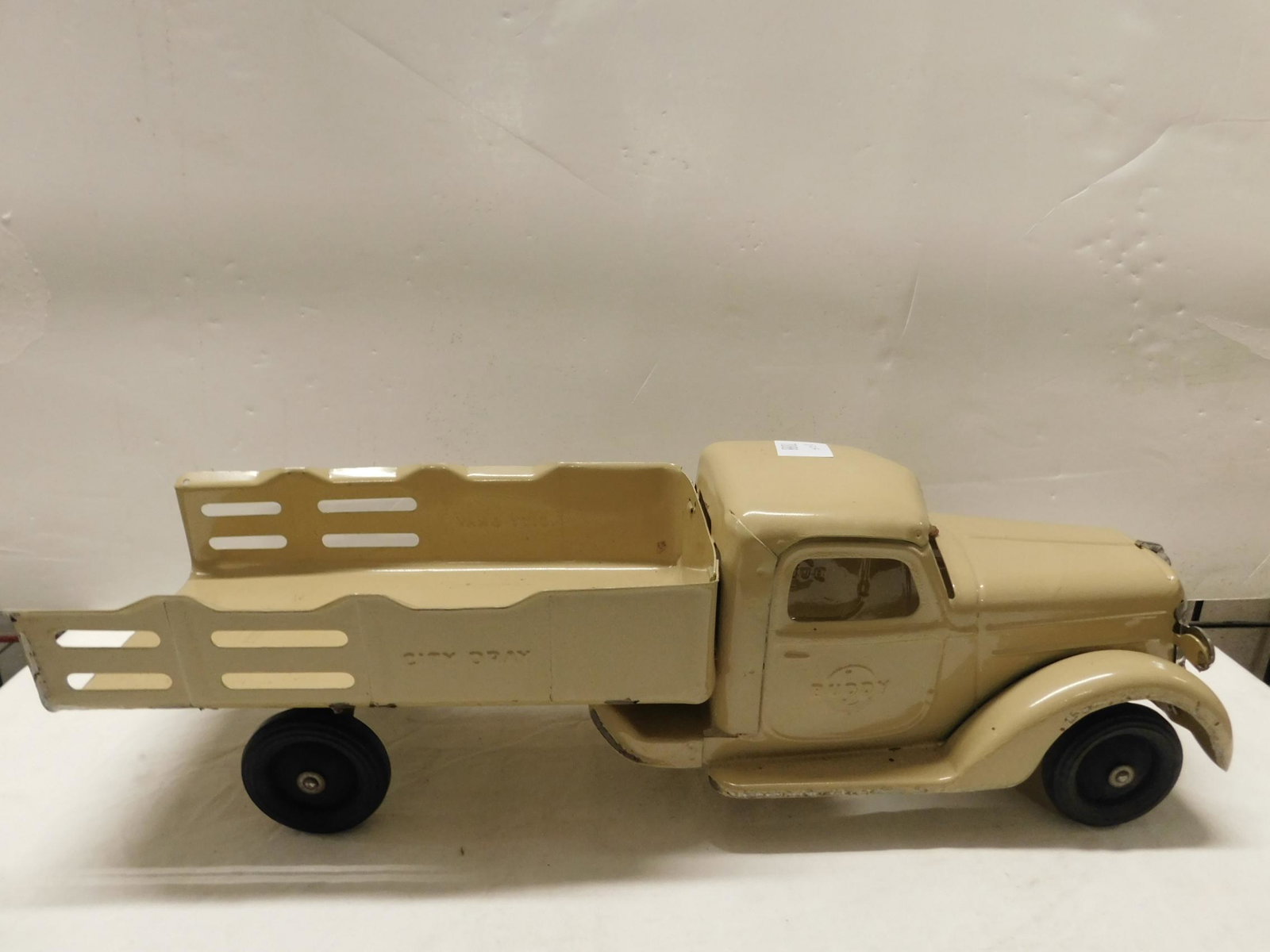 Vintage Buddy L Pressed Steel Truck: Vintage Buddy L Pressed Steel Truck "City Dray", beige with fixed bed, hard rubber wheels, 21" l. CONDITION: Minor paint wear and scratching from age and use.
