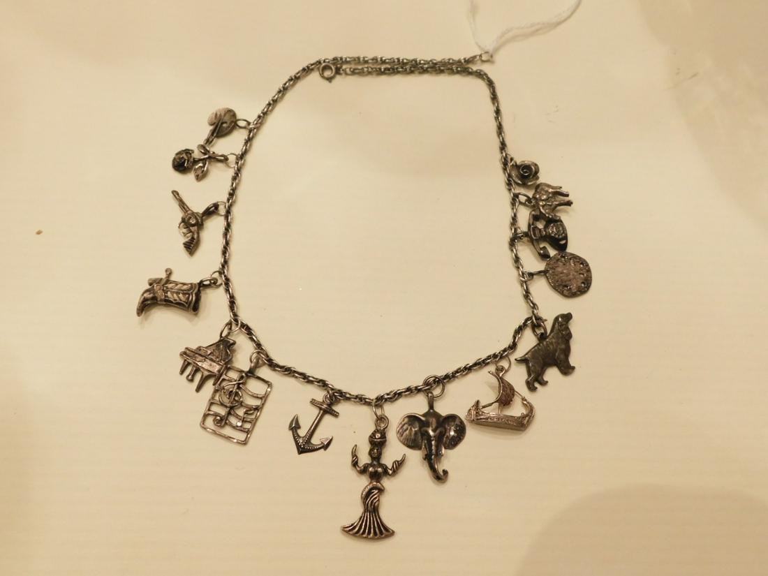 Sterling Charm Necklace: Sterling Charm Necklace, a 17" link chain holds fifteen assorted charms, early to mid 20th C, 1.36 ozts. [7] CONDITION: Good, used condition, tarnished.