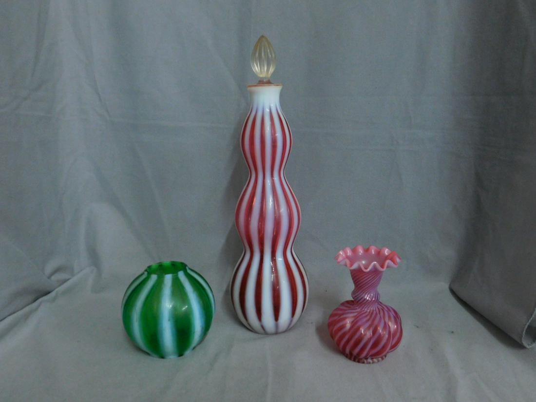 Fenton Glass New World Decanter: Fenton Glass New World Decanter, in cranberry opalescent with vertical striping. Crystal stopper. Along with a green opalescent ivy ball and a cranberry opal swirl melon vase. CONDITION: All three pie