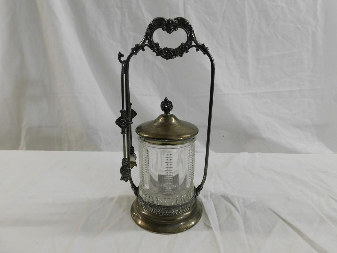 Victorian Pickle Caster: Victorian Pickle Caster, clear molded glass caster with ribbed and panel design, seats in Poole quadruple plate stand with garland and acanthus crest, plus tongs, 10 1/2"h, circa 1880-1900. CONDITION: