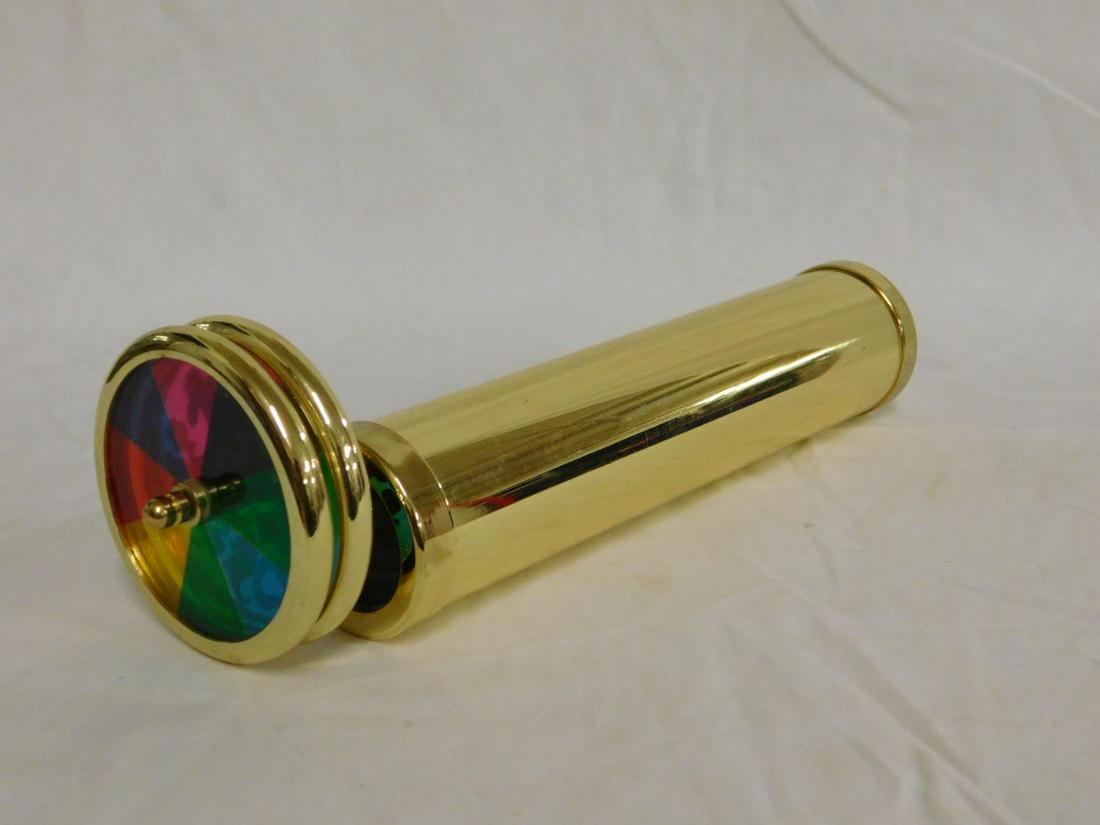 Brass Cylinder Kaleidoscope: Brass Cylinder Kaleidoscope with twin figural and fan blade form glass, swizzle disks, length 8 3/4".[20] CONDITION: Very good.