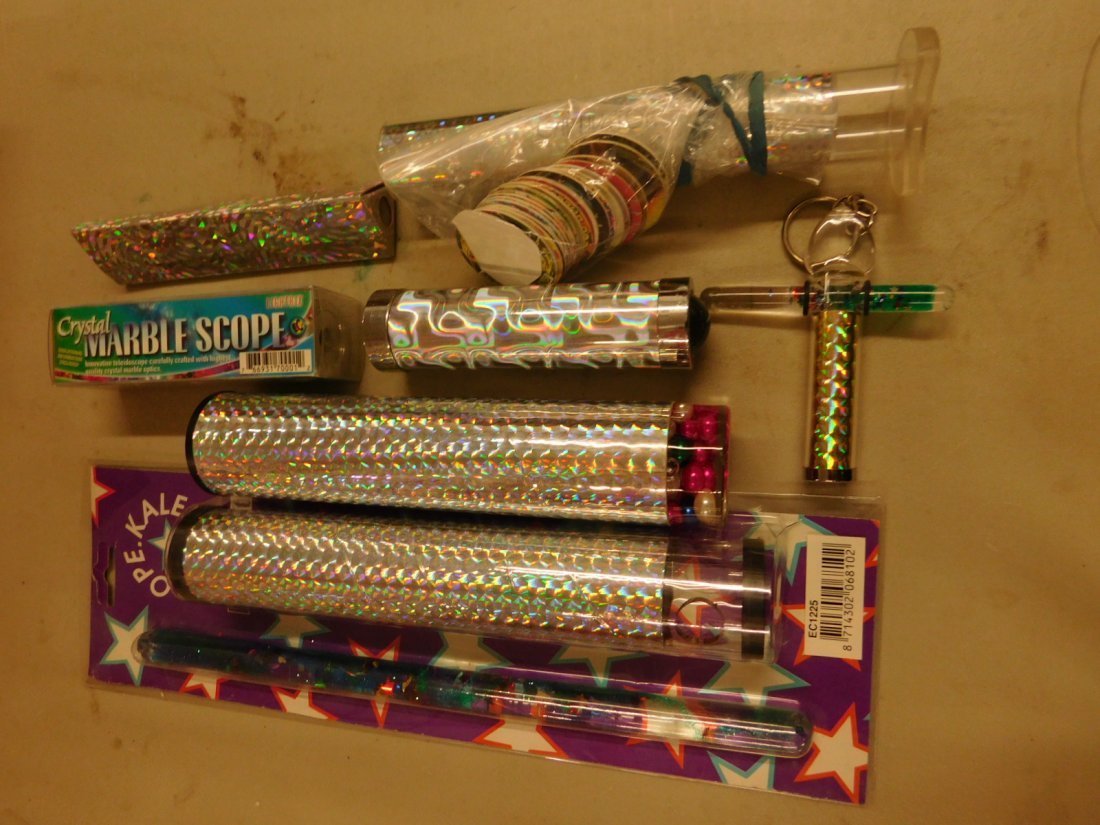 7 Kaleidoscopes: 7 Kaleidoscopes, all with iridescent foil designs from 4" to 10". [42] CONDITION: Two new in original packaging.