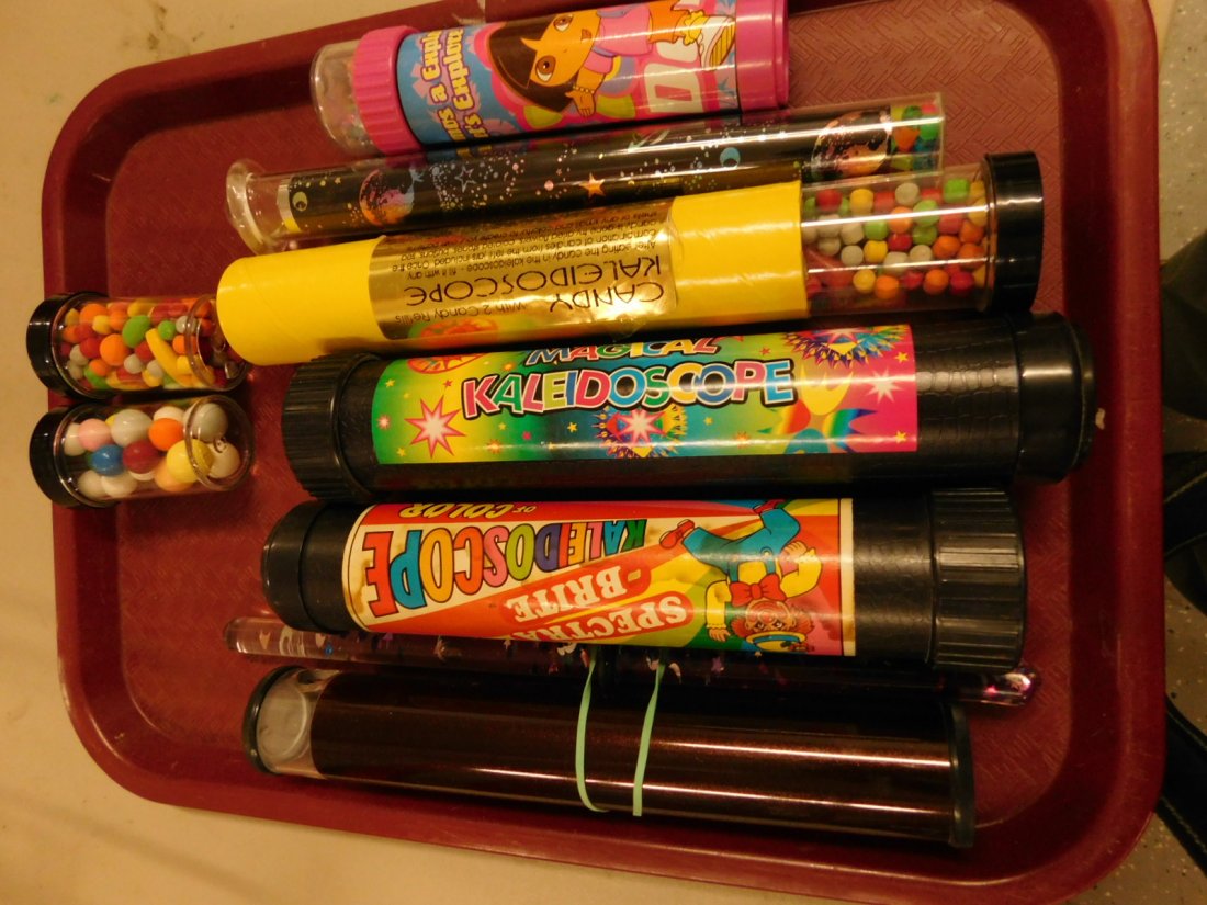 6 Kaleidoscopes: 6 Kaleidoscopes in Lucite and plastic, plus two jars of candy inserts, from 6 1/2" to 10 1/2". [43] CONDITION: Very good used condition.