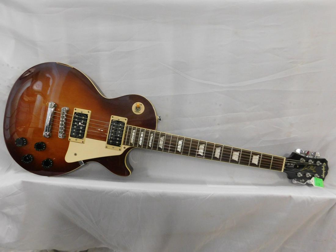 Epiphone Les Paul Guitar: Epiphone Les Paul Standard solid body electric Guitar Honey Burst 6 string. Guitar 40"; neck 25 1/2". "EE06050845" Black hard case. CONDITION: Good, used, working. [24]