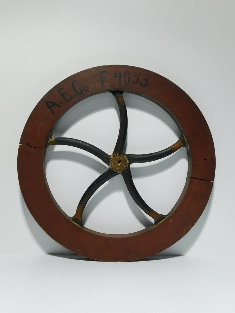 Wooden Pattern Mold: Wooden Pattern Mold, hand-made pattern mold for sand-casting a cast iron flywheel, with thick rim and elegant, slightly curved spokes. Painted red and black-gray. Marked on one side "A.E. Co. F 4053".