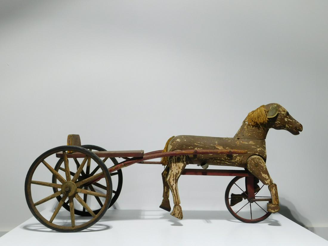 Antique Folk Art Horse & Cart Toy: Antique Folk Art Horse & Cart Ride-On Toy, consisting of a carved, articulated wooden horse attached to a two-wheel ride-on cart or trap with rubber tires. Horse with string mane and tail, cloth ears.