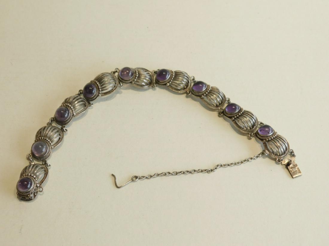 Vintage Sterling & Amethyst Bracelet: Vintage sterling & amethyst bracelet, modified bee-shaped panels with engraved domed rod backs & bezel set round cabochon amethyst, safety chain, length 7". CONDITION: Slightly tarnished used.