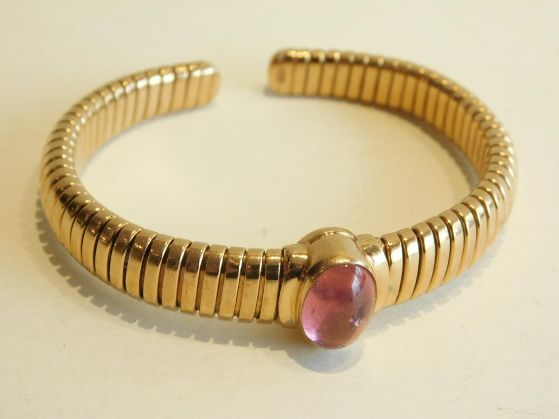 Bvlgari 18k & Ruby Cuff Bracelet: Bulgari 18k & Ruby Cuff Bracelet "Tubogas" open flex band, bezel set oval cabochon ruby; interior size 2 1/8", 29.8 DWT, original suede pouch. [10] CONDITION: very good, 2 visible imperfections in rub