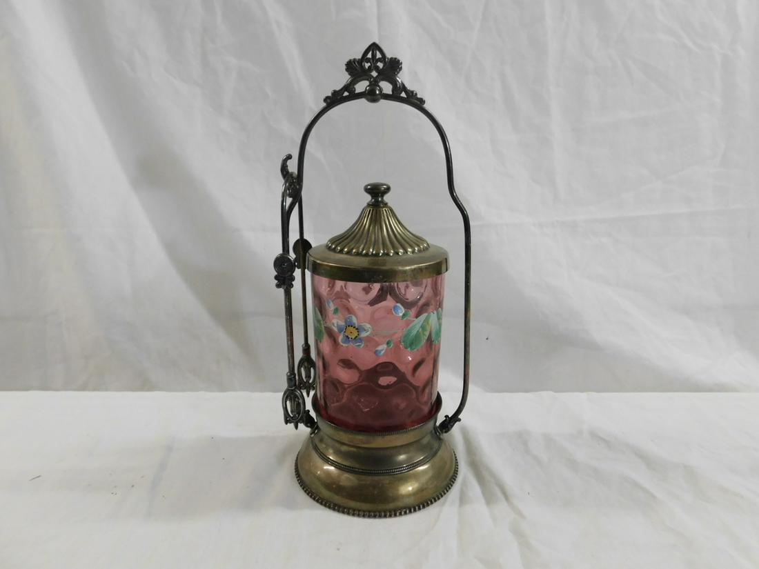 Victorian Pickle Caster: Victorian Pickle Caster, cranberry glass inverted thumbprint caster with a band of enameled flowers, rests in a Rogers quadruple plate stand with tongs, circa 1880-1895, 10 1/2"h. CONDITION: Very good