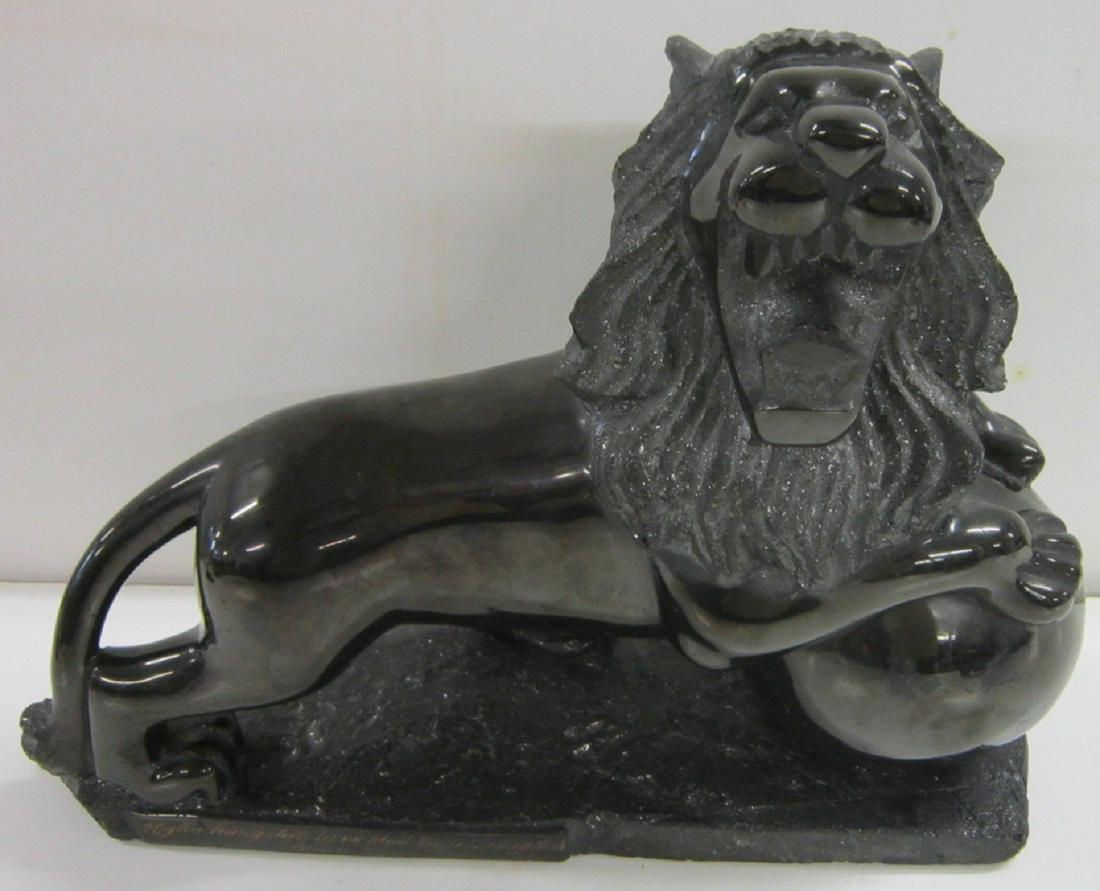 Carved Coal Lion Sculpture: Carved Coal Lion Sculpture, depicting a standing lion with his front paws on a ball or orb, inscription on the base in gold in Vietnamese (?). Early 20th c. Size 13" l. x 4 1/2" x 10" h. CONDITION: po