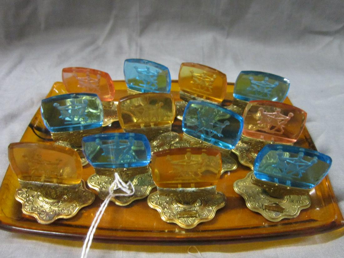 Twelve Vintage Czechoslovakian Place Card Holders: Twelve Vintage Czechoslovakian Place Card Holders: A set of 12 Art Deco place card holders, each consisting of a pressed and cut intaglio glass cameo set on a gold-colored metal foot. The glass cameos