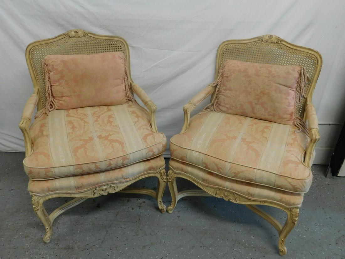 Pair French Provincial Bergere Chairs: Pair French Provincial Bergere Chairs. Antiqued white finished with button and foliate carved crest, caned back, open arms and upholstered seats. Mid 20th c. 37" h. Condition;Light wear from use.