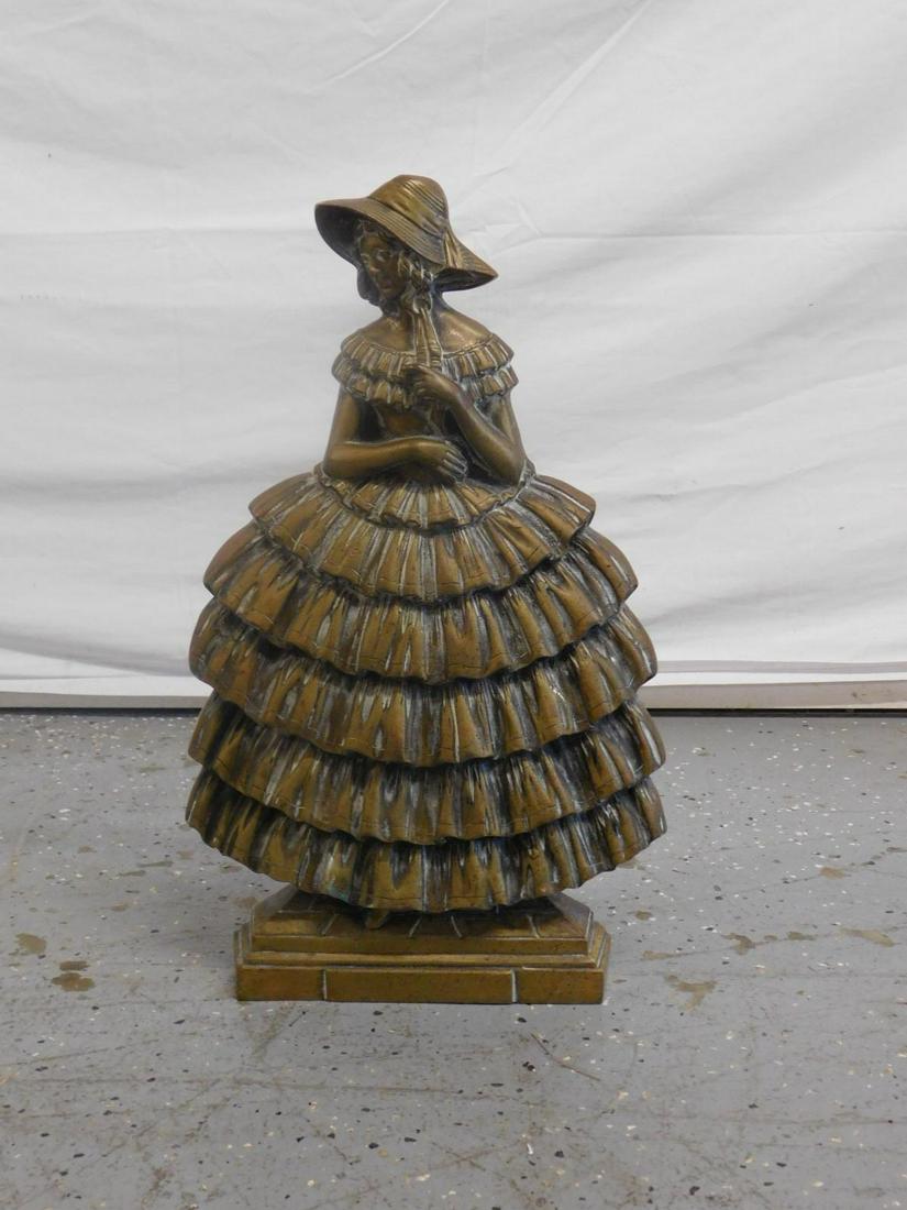 Huge Antique Brass Southern Belle Door Stop: Huge Antique Brass Southern Belle Door Stop. Standing lady with Bonnet and layered, ruffled dress, verso with an attached cylinder for holding an umbrella (?). Late 19th c. Size: 17 1/4" x 10 1/2" x 6
