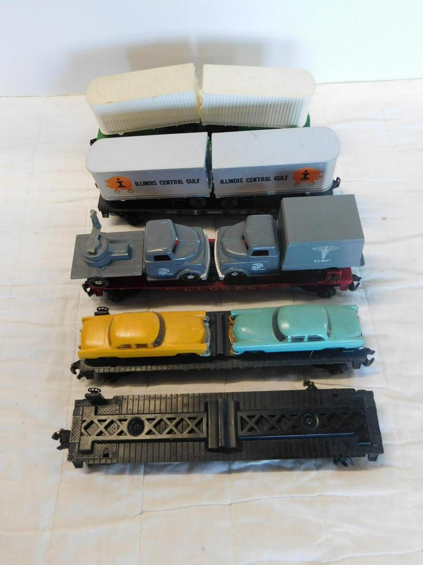5 Lionel Flat Transport Train Cars: Five Lionel Flat Transport Train Cars, "O" gauge, loose, no boxes including: Postwar: Military Vehicle transport USMC truck car, 6806, with gray USMC Medical truck and Radar disc, two 6424 automobile 