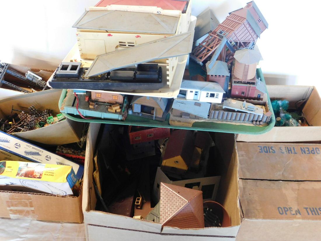 Lot of Plasticville Train Building: Lot of Plasticville Train Building, loose, no boxes, assorted HO gauge buildings, tressel sets, water and light tower, a few figures and wire poles, trees. CONDITION: Used, good, some pieces may be mi