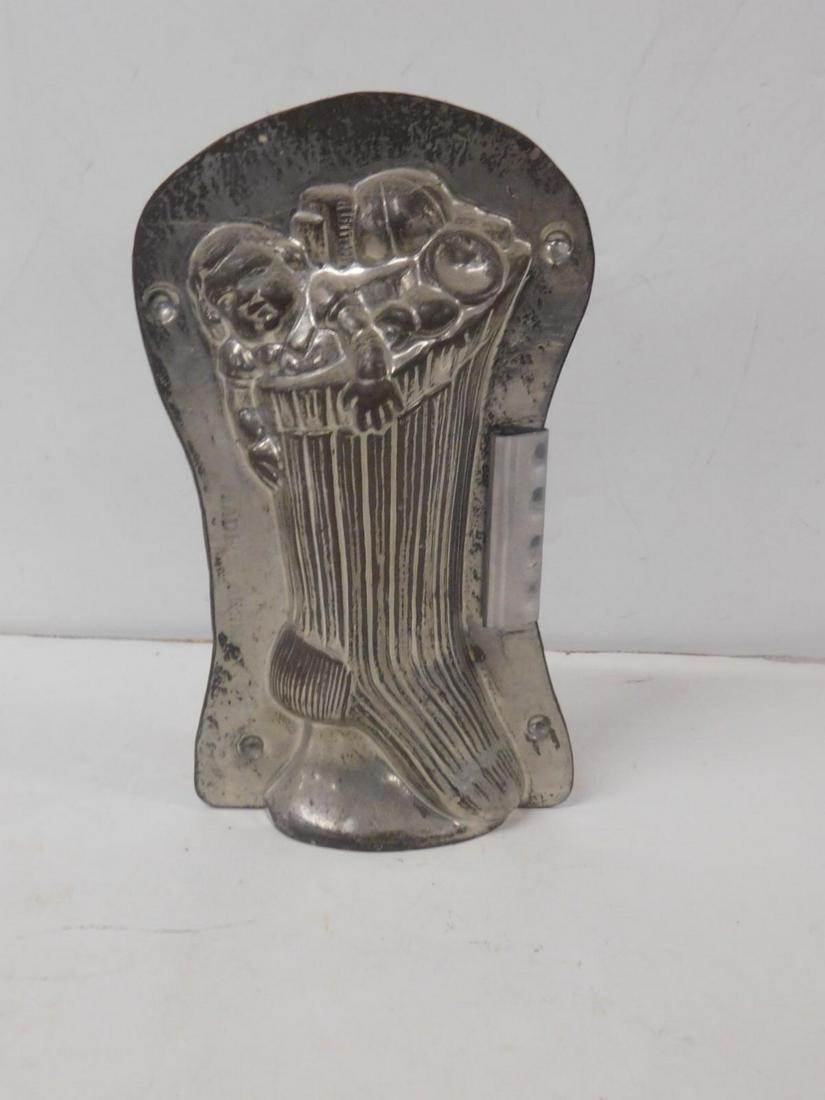 Antique Christmas Stocking Chocolate Mold: Antique Christmas Stocking Chocolate Mold, metal with one clip, depicts Christmas stocking full with doll, ball and other toys, 7 3/4" x 4 1/2" x 2". CONDITION: Very good.
