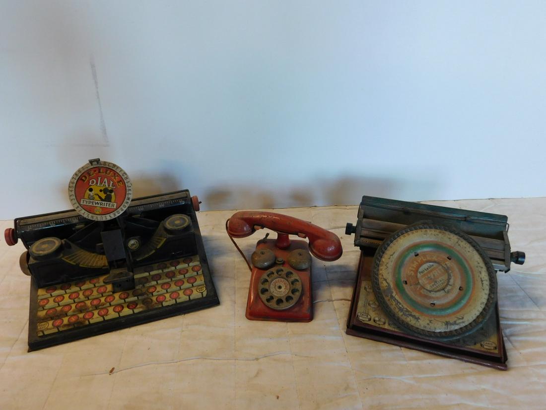 2 Vintage Tin Litho Typewriters & Telephone: Two Vintage Tin Litho Typewriters and Telephone including: Simplex portable typewriter "Special Demonstration Model, 7 1/2" x 10" x 4 1/4'h and Deluxe dial typewriter, 7 1/4" x 11" x 8"h, plus Speed p