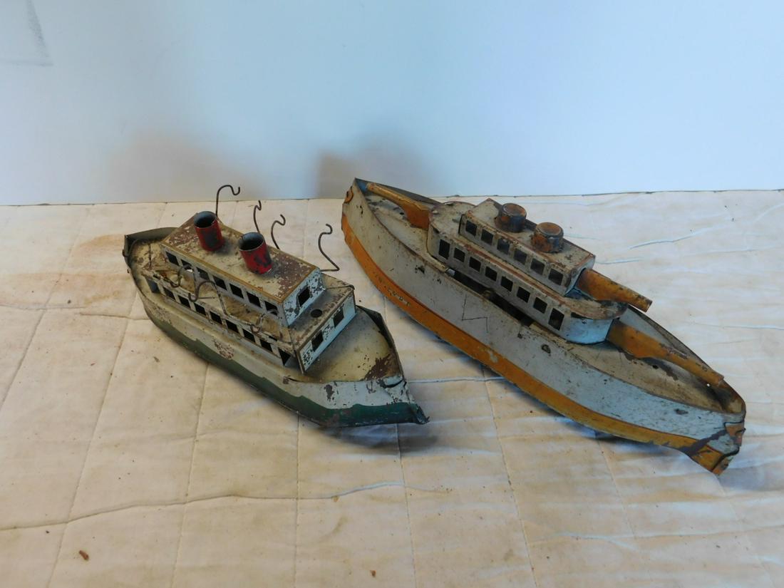 2 Antique Pressed Tin Toy Ships: Two Antique Pressed Tin Toy Ships, both tin litho with two stacks including: larger battleship with front and back turrets (missing one top turret), two center wheels underneath with single wheels fro