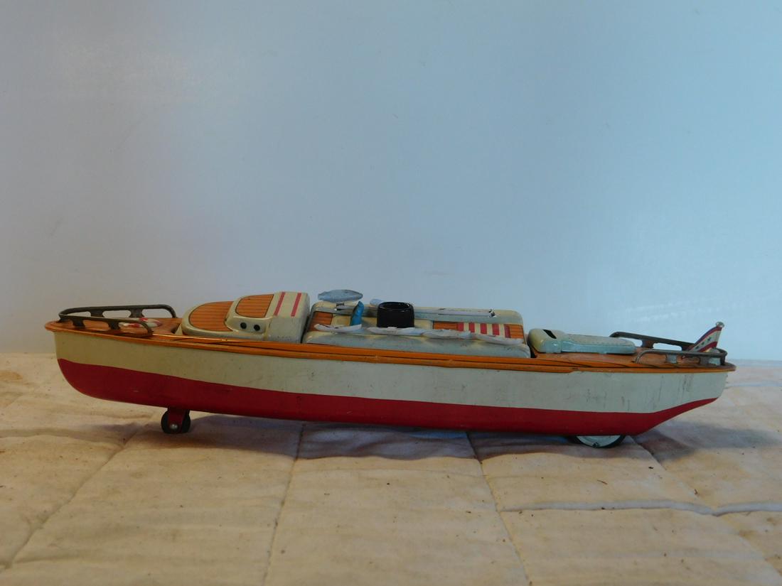 Japan Tin Friction Reversible Boat: Japan Tin Friction Reversible Boat, tin litho yacht, 12 1/4"l with reversible center section, rotates 180º to turn into battleship,marked Japan at back of boat, tin friction wheels underneath. CONDIT