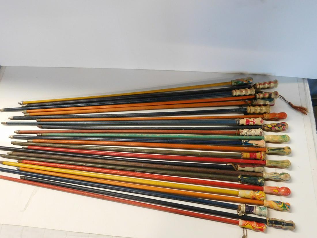 24 Vintage Wood Top Carnival Canes: 24 Vintage Wood Top Carnival Canes, all swirl painted wood tops, 3" - 3 1/4", all with mostly painted wood shafts, ferrule ends, 34"h - 36"l. CONDITION: Some cane head have minor paint loss, shafts ha