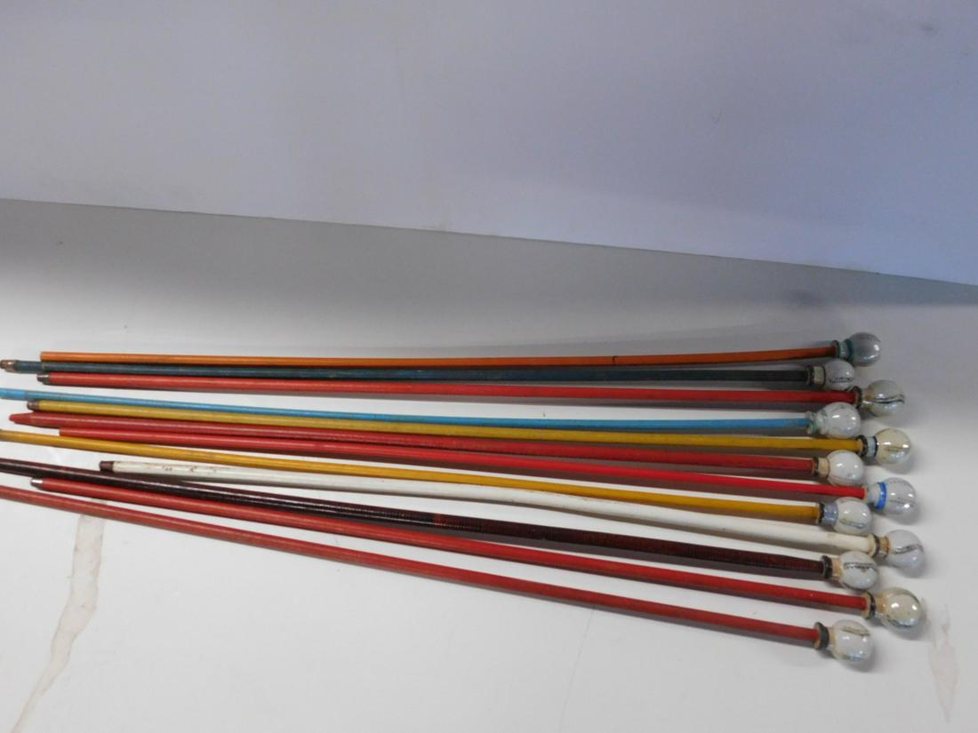 12 Porcelain Head Baseball Carnival Canes: Twelve Porcelain Head Baseball Carnival Canes, all with 2" porcelain baseball form cane heads on painted wood shafts (8 with ferrule tips at end) 34 1/2" - 36" long. CONDITION: Some paint loss on base