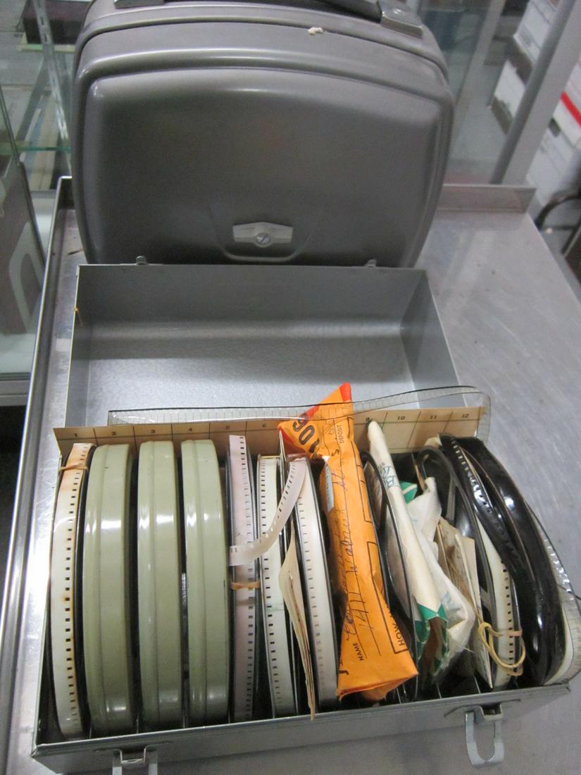 Vintage 8mm Home Movies and Bolex Projector: A metal film box containing six reels of 8mm home movie film, and some other, smaller rolls. Based on the notes in the box, they all appear to be American locations. From the estate of William Nezowy,