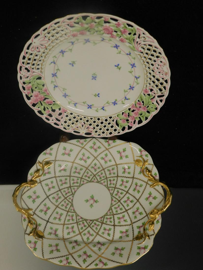 2 Herend Plates: Two Herend Plates, Hungary, includes: 9 1/2"d reticulated border with pink flowers and center with blue flowers and an 11 1/4" x 10" double gilt handle chop plate with red floral sampler pattern. COND