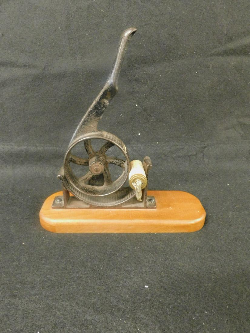 Antique Wheel Nut Cracker: Antique Wheel Nut Cracker, cast iron, a spoked wheel with leaver revolves on a ribbed demi lune platform; late 19th C, screwed upon a recent wood base, 9" x 5" x 3 1/2". CONDITION: Very good.