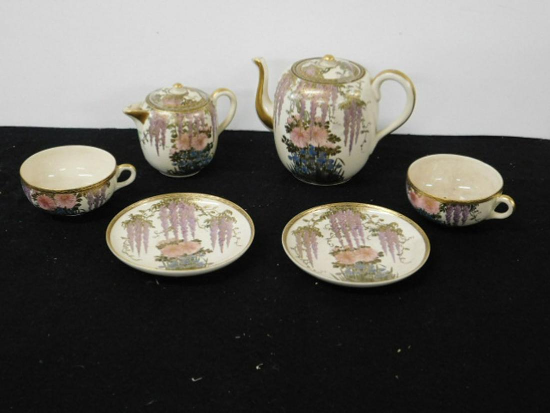 Japanese Satsuma Tea Set: Japanese Satsuma Tea Set, floral pattern with gold highlights, chop marks on base, includes: tea pot, covered creamer, two cups and saucers, late 19th C. CONDITION: One cup with crazing and slight dis