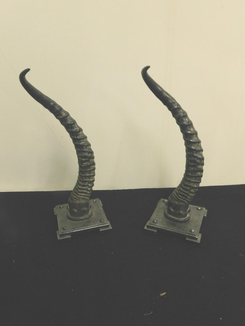 Pr Horn Sculptures: Pair Horn Sculptures, faux ribbed 12" horns mounted on a metal stepped square base, late 20th C, overall h 13". CONDITION: Very good, one horn with a 3/4" circumference crack.