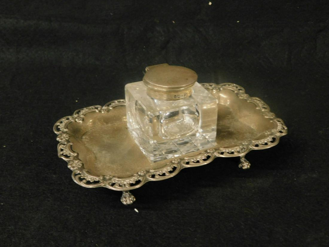English Sterling Inkwell: English Sterling Inkwell by Walker and Hall, Sheffield, 1905-06 scalloped, embossed and pierced border, four claw feet, crystal ink well with sterling top, 4.41 ozts base only, 3" x 7 1/4" x 4 7/8". [
