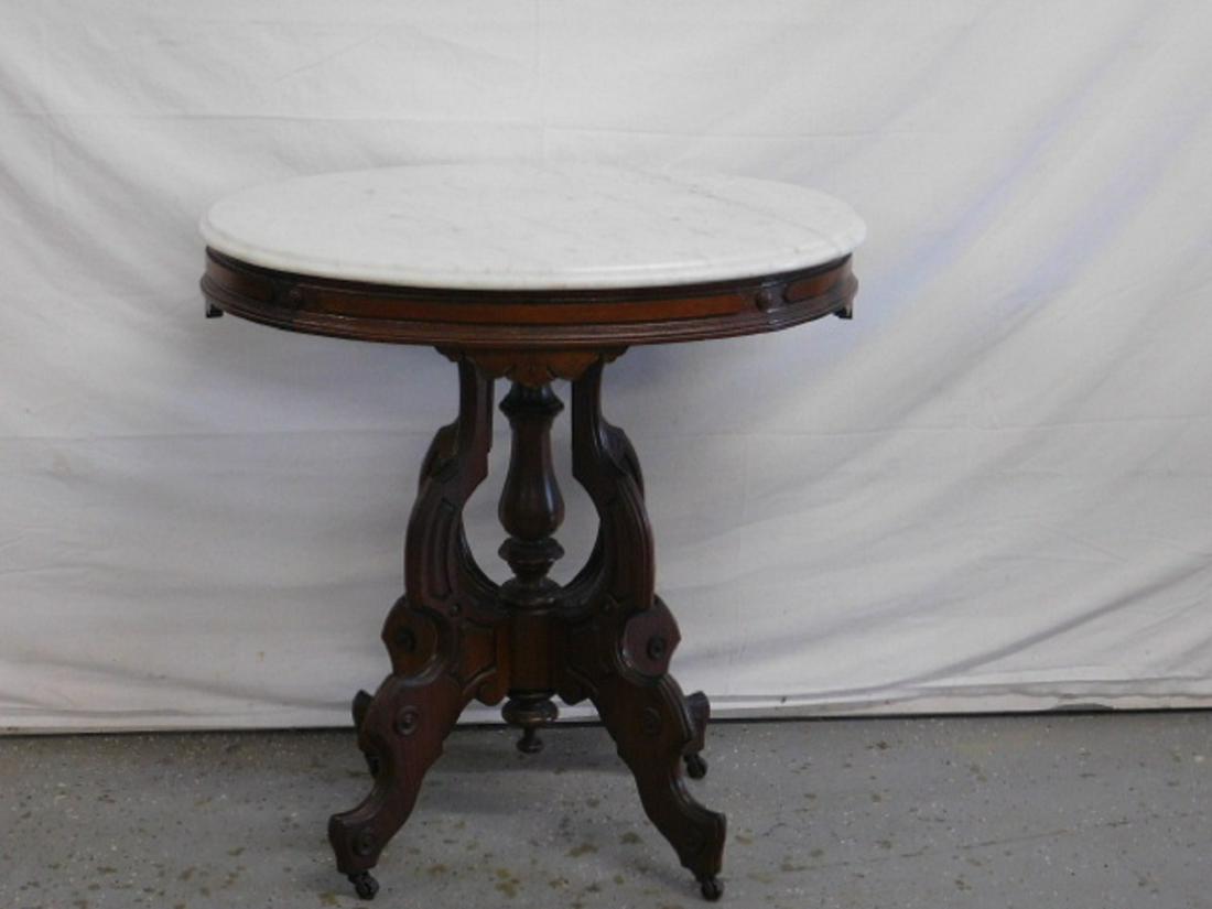Victorian Renaissance Revival Center Table: Victorian Renaissance Revival Center Table, oval veined white marble top, walnut base with central turned column and four flat curved and shaped supports and legs, late 19th C, 30 1/2" x 22" x 34". CO
