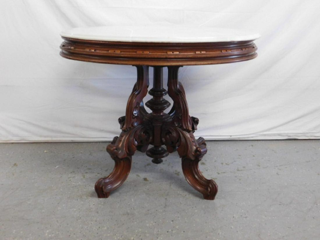 Rococo Revival Center Table: Rococo Revival Center Table, walnut, elaborate acanthus and scroll carved heavy four leg base with central column, oval white marble top on carved and stepped frieze, circa 1860-70, 28" x 36 1/2" x 29