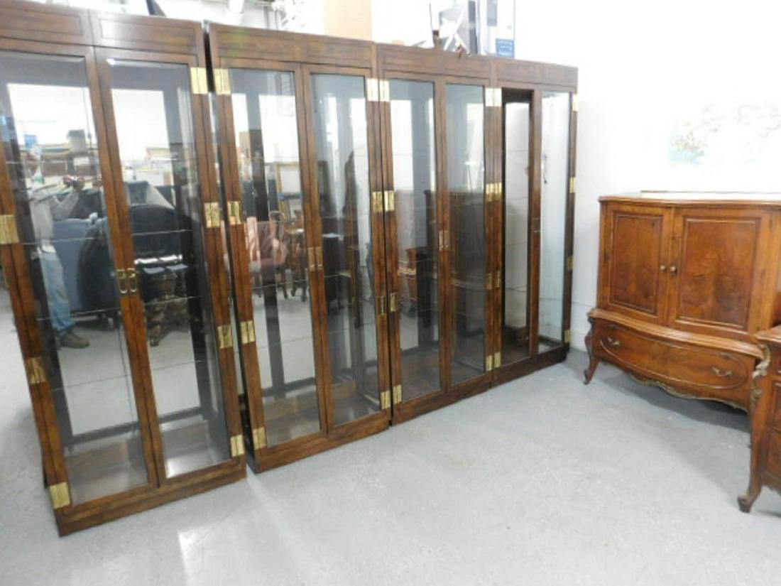 4 Henredon Curio Cabinets: Four Henredon Curio Cabinets, oak, campaign style with brass hardware, beveled glass doors and shelves, lighted mirror backs, 32" x 15" x 82". CONDITION: Very good.